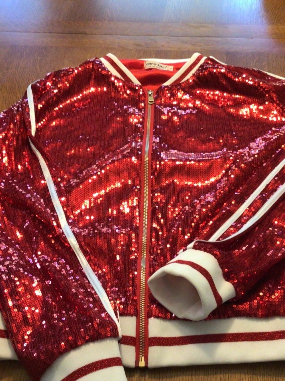 Red sequin bomber jacket with striped detail on sleeves. EUC